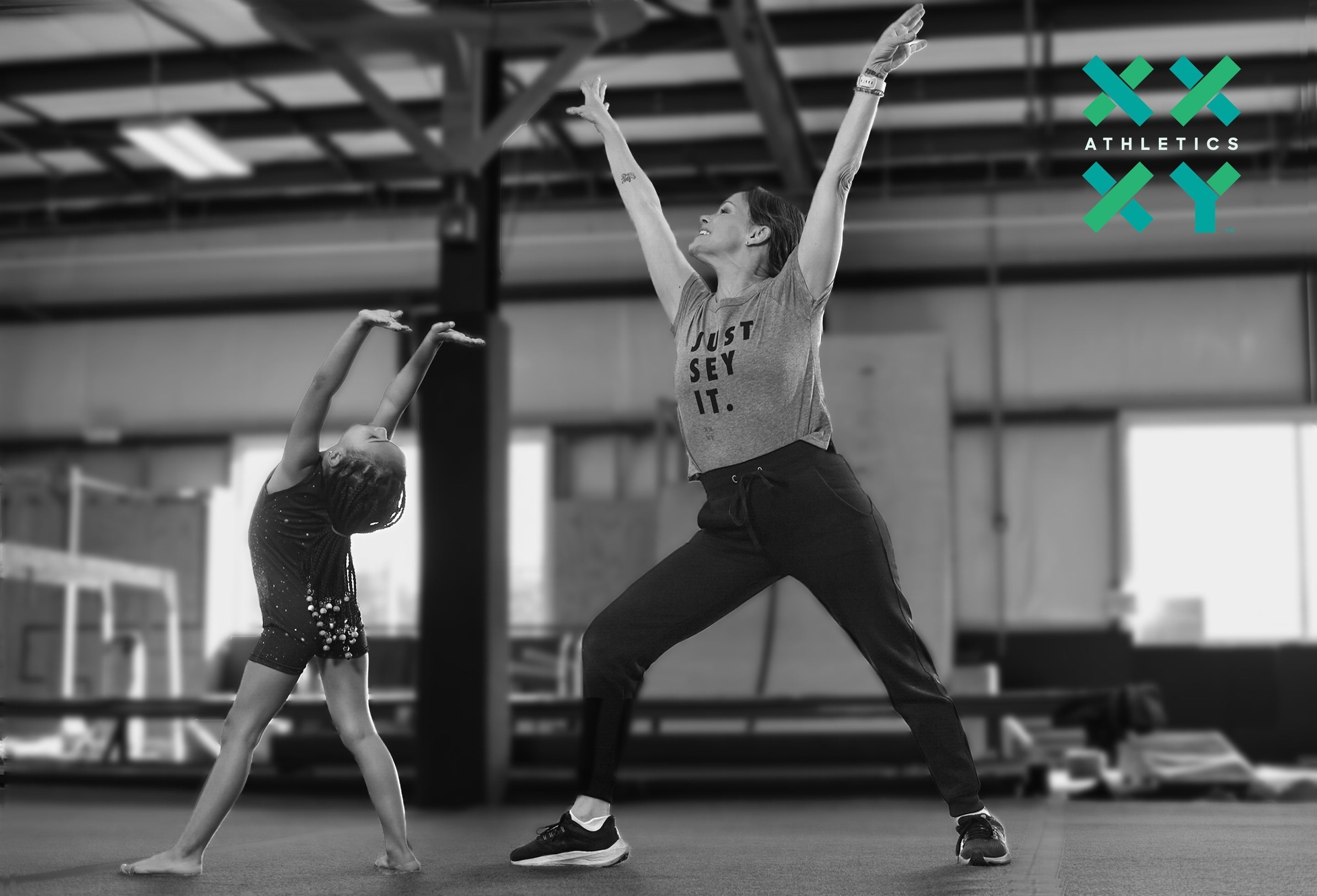 Founder Jennifer Sey teaching a young child how to pose for gymnastics while wearing a Just Sey It Tee.